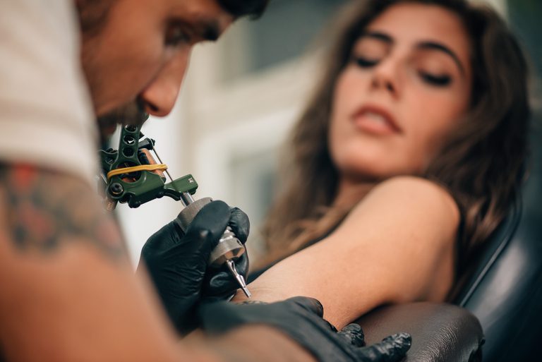 Tattoo,Artist,Creating,A,Tattoo,On,A,Girl's,Arm.,Focus